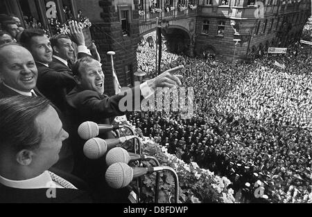 Eine begeisterte Menschenmenge an der Frankfurter Nicolaikirche feiern die deutschen Spieler, die auf dem Balkon des Rathauses am 31. Juli 1966 stehen. In der Front des Frankfurter Oberbürgermeister Willi Brundert, in der Mitte mit Index Zeigefinger Uwe Seeler und hinter ihm Franz Beckenbauer. Host Land England hatte die FIFA World Cup-Finale 1966 4:2 nach Verlängerung gegen Deutschland gewonnen. Stockfoto