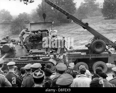 Amerikanische Mechanik ändern den Motor eines Patton-Panzers unter den Augen der westlichen Alliierten Offiziere im Rahmen der alliierten Panzer zu Übungszwecken im Grunewald in Berlin am 11. Oktober 1962. Die Übung war Bestandteil einer alliierten Panzer Manöver, in denen Truppen und Fahrzeuge der amerikanischen, französischen und britischen Streitkräfte beteiligt. Stockfoto