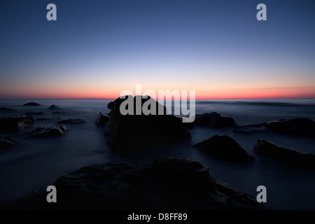 herrliche blaue Meer Sonnenaufgang mit vielen Felsen Stockfoto