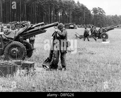 Soldaten der US Army Energiebereitstellung Geschütze, die nur mit Fallschirmen Fracht bei der airborne Manöver "Wind Drift" in Senne in Nordrhein-Westfalen am 20. August 1961 fallen gelassen worden wäre. Mehr als 5.000 US-Soldaten, unter ihnen fast 2.500 Fallschirmjäger, beteiligen sich an der 10-Tage-Manöver. Stockfoto