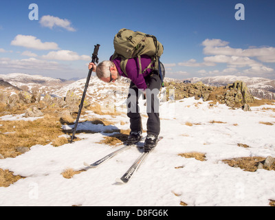 Ein älterer Mann Langlauf auf großen Torfgebieten in Lake District, Cumbria, England. Stockfoto