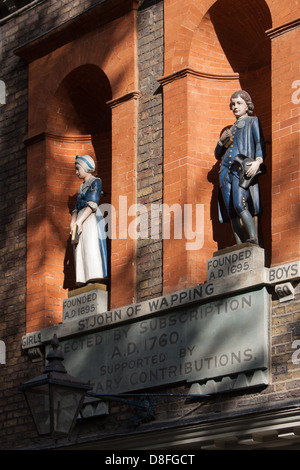 Blauer Mantel Statuen von jungen und Mädchen Exterieur von St John Scandrett Street, Old-School Wapping. Das Gebäude stammt aus dem Jahre 1756. Stockfoto