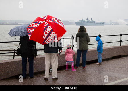 Liverpool, Vereinigtes Königreich 28. Mai 2013.   Zuschauer mit Liverpool Echo Werbe roten Regenschirm in New Brighton die Abfahrt von der HMS Bulwark, bei Regen und Nebel, als die Marine Flotte verlässt Merseyside nach der Schlacht der atlantischen Erinnerungen über das Wochenende und Feiertagen. Die koordinierte Abfahrt bei der Handelsmarine Schiffe einen Gateway für die 20 anderen zur Verfügung gestellt Versand nach entlang der Uferpromenade vorbei und fahren flussabwärts, Senkung des Vorhangs über ein dicht gepacktes Programm von Veranstaltungen über das BOA70-Gedenk-Wochenende. Bildnachweis: Mar Photographics / Alamy Live News Stockfoto