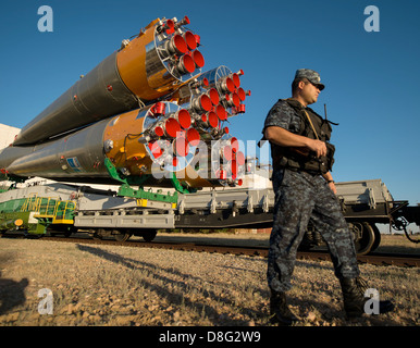 Ein Polizist Spaziergänge entlang dem Raumschiff Sojus TMA - 09M, wie es mit dem Zug auf der Startrampe in Baikonur Kosmodrom 26. Mai 2013 in Kasachstan wird ausgerollt. Der Start der Sojus-Rakete auf der internationalen Raumstation ISS mit Expedition 36/37-Crew ist für Mittwoch geplant. Stockfoto