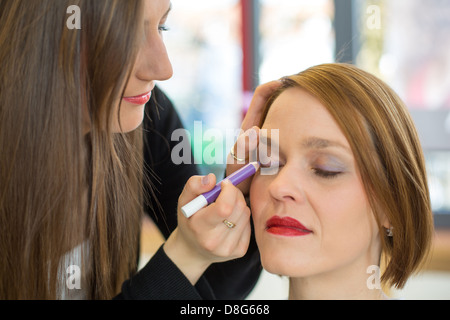 Kosmetikerin Kunde Lidschatten zuweisen Stockfoto