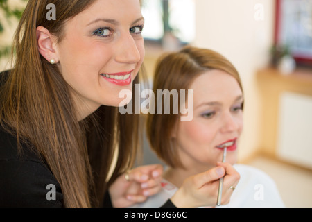 Kosmetikerin Lipgloss oder Lippenstift für Kunden Stockfoto