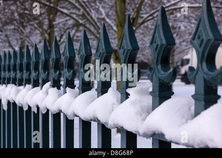 Verschneite Metallzaun Eisengitter mit Speer geformt Kreuzblumen, UK Stockfoto