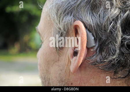 Hörgerät hinter dem Ohr eines Mannes Stockfoto