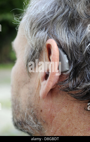 Hörgerät hinter dem Ohr eines Mannes Stockfoto