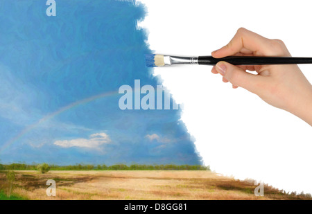 Die Hand mit einem Pinsel zeichnet eine Landschaft Stockfoto