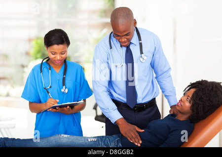 Afrikanischen Arzt und Krankenschwester Untersuchung Patientin im Büro Stockfoto