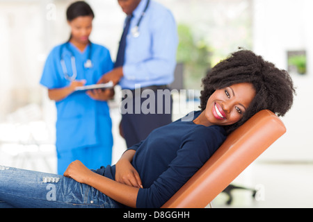 glücklich Afrikanerin liegen auf ärztliche Prüfung Bett und wartet auf medizinischer checkup Stockfoto