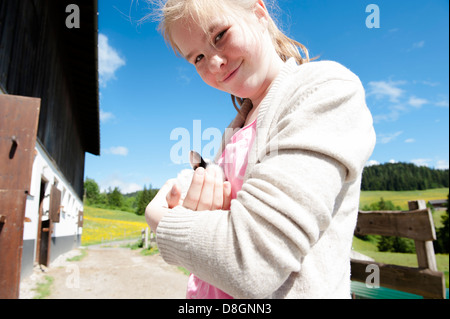 Lara Maunder (11, Tochter des Fotografen) hält ein Neugeborenen Kaninchen im Rotenau Hof, einem Bergbauernhof in Hopfgarten, Tirol, Österreich Stockfoto