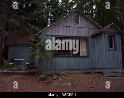 Eine gemütliche Hütte am Priest Lake in Idaho, umgeben von üppigem Grün und natürlicher Schönheit. Die Hütte liegt vor einem Hintergrund von Bäumen und dem ruhigen Wasser des Sees und bietet einen friedlichen Rückzugsort. Stockfoto
