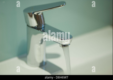 Wasser aus einem zeitgenössischen Hahn gießen Stockfoto