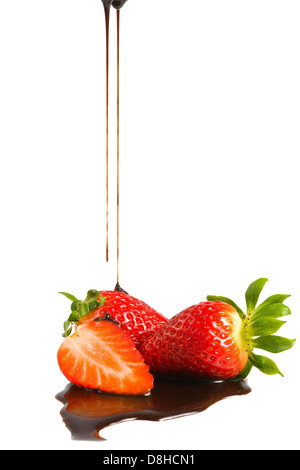 Schokoladen-Sirup wird auf eine Erdbeere in einem Löffel gegossen Stockfoto