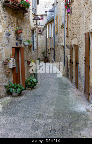 Türen und Fenster des mittelalterlichen Sandsteinbauten entlang der bezaubernden schmalen gepflasterten Straße in Sarlat, Dordogne Region Frankreich Stockfoto