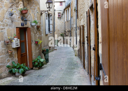Türen und Fenster des mittelalterlichen Sandsteinbauten entlang der bezaubernden schmalen gepflasterten Straße in Sarlat, Dordogne Region Frankreich Stockfoto