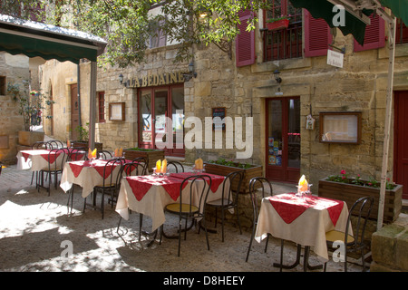 Sonnendurchfluteten Innenhof Restaurant unter den mittelalterlichen Sandsteinbauten in charmanten Sarlat, Dordogne Region Frankreichs Stockfoto