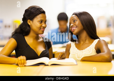 zwei afrikanische Studentinnen lesen Buch in Bibliothek Stockfoto