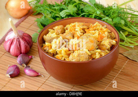 Pilaw in eine braune Schale und Gemüse auf dem Tisch Stockfoto