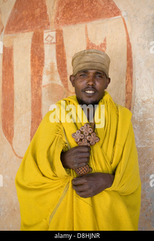 Priester in gelben Roben halten ein hölzernes Kreuz im Kebran Gabriel, Tana-See, Gondar Region, Äthiopien, Afrika Stockfoto