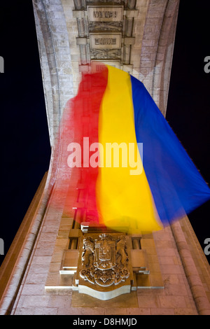 Europa, Rumänien, Bukarest, Triumphbogen (Arcul de Triumf) und rumänische Flagge, die nachts beleuchtet Stockfoto