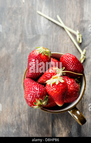 Erdbeeren im Cup über Holztisch, Tiefenschärfe, kopieren Raum Stockfoto