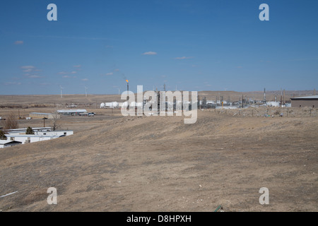 Ironisch Energie Foto mit Windmühlen im Hintergrund und ein Öl / Gas Raffinerie- und Gastechnik flare im Vordergrund. Stockfoto