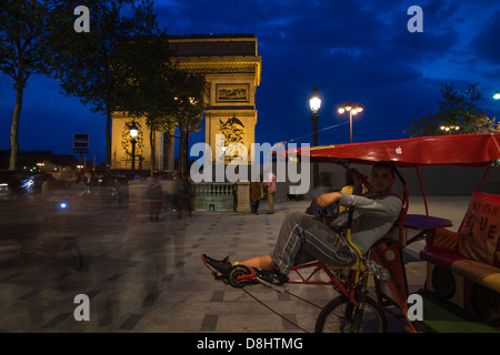 Paris, Frankreich. Velo-taxis (Velotaxis) und Cyclobulles warten in der Nähe des Arc de Triomphe als Menschen vorbei. Stockfoto