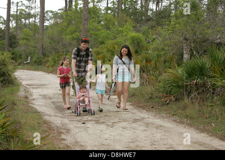 Eine Familie, die einen Park entlang spaziert und einen gemütlichen Spaziergang in einer natürlichen Umgebung im Freien genießt. Stockfoto