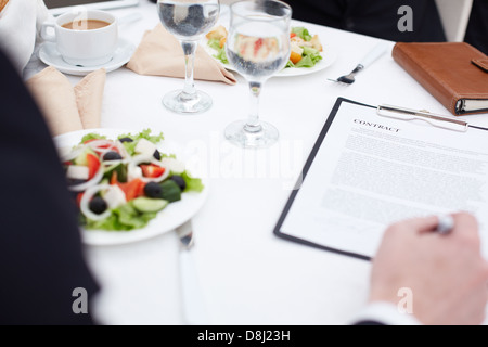 Nahaufnahme der Geschäftsmann Hand Vertragsunterzeichnung beim Business-lunch Stockfoto