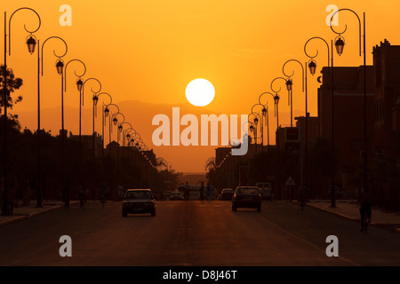 Silhouette Stadtszene mit Straße und Hausnummer Lampen gegen Sonnenuntergang. Stockfoto