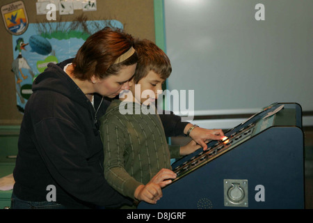 Mutter und Sohn teilen einen freudigen Moment, lachen und spielen zusammen. Das Bild fängt die Bindung und das Glück zwischen ihnen ein und betont familiäre Verbindung und Liebe. Stockfoto