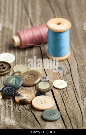 Spulen von Fäden und Knöpfe auf alten Holztisch Stockfoto