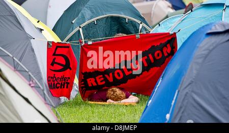 Ein Mann liegt unter einem Banner mit der Schrift "Revolution" zwischen zwei Zelten im Blockupy Lager in Frankfurt Am Main, Deutschland, 30. Mai 2013. Viele tausend Aktivisten sollen das diesjährige Blockupy mitmachen. Foto: NICOLAS ARMER Stockfoto