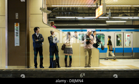 Passagiere, die darauf warten, von der Plattform für ihren Zug am Bahnhof Omiya, Japan Stockfoto