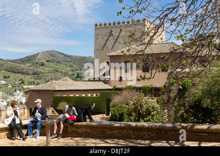 Das Exterieur des die Nasridenpaläste innerhalb der Alhambra Komplex, Granada, Spanien gesehen. Menschen entspannen im Vordergrund. Stockfoto