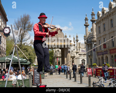 Straßenunterhaltung - Mann auf Drahtseil in der Nähe von Brighton Royal Pavilion in Brighton Festival 2013 Stockfoto