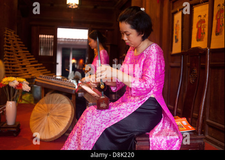 Hanoi, Vietnam - Temple of Literature, Frau spielt traditionelles Musikinstrument Stockfoto