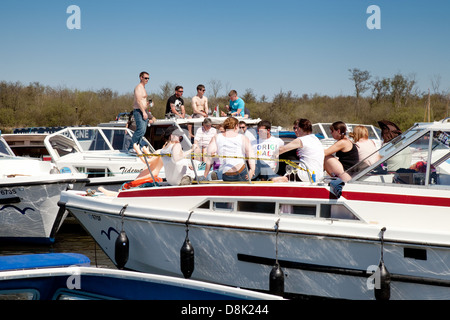Jugendliche genießen die Frühlingssonne auf Booten, Malthouse breit, Norfolk Broads, England UK Stockfoto