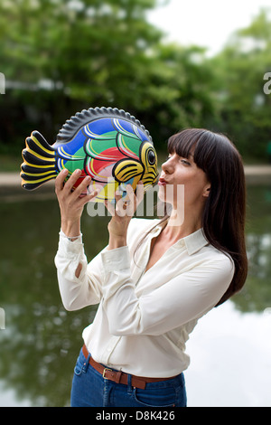 Ein Mädchen mit einem Keramik Fisch Stockfoto