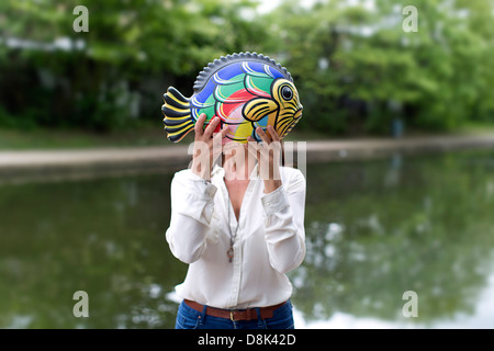 Ein Mädchen mit einem Keramik Fisch Stockfoto