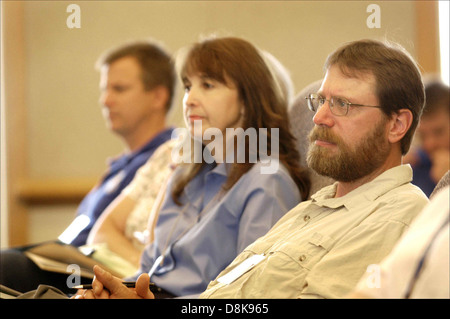 Drei Personen lauschte an den Lautsprecher während der Sitzung. Stockfoto