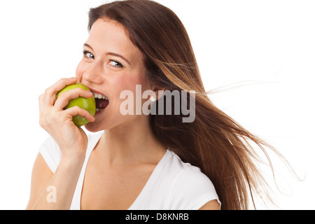 Junge Frau beißen einen grünen Apfel, isoliert auf weiss Stockfoto