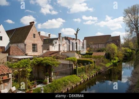 Traditionelle Gebäude in Brügge spiegelt sich in den Kanal. Weißen geschwollenen Wolken in einem Pastell blauen Himmel oben Stockfoto