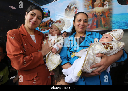 neu katholischen koptische Getauften Babys in den Armen ihrer Mütter, Asyut Diözese, Ägypten. Stockfoto