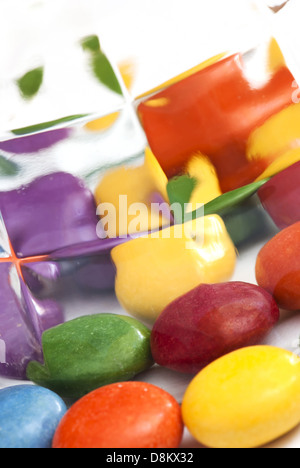 Bunte Smarties spiegeln sich im Glas. Stockfoto