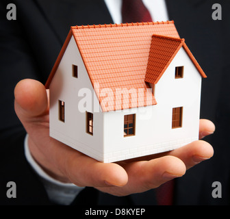 Hand des Unternehmers mit dem Haus Stockfoto