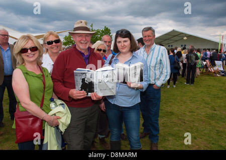 Hay-on-Wye, UK. 31. Mai 2013. David Blair 64, (Mitte mit Hut) ein Berater hat mit Freunden aus Belfast für die Le Carre Veranstaltung kommen.  Le Carré Fans bilden eine riesige Schlange unter einem ominösen Himmel zu ihrem Buch signiert. John Le Carré, der Schöpfer von George Smiley und Autor von vielen Spion Meisterwerke, sprach über seine Arbeit in einem Doppel-Länge Interview mit Philippe Sand bei seinem ersten Besuch in The Hay-Festival. Sein neue Roman ein zarte Wahrheit erfolgt am 25 April. Photo Credit: Graham M. Lawrence/Alamy Live-Nachrichten. Stockfoto